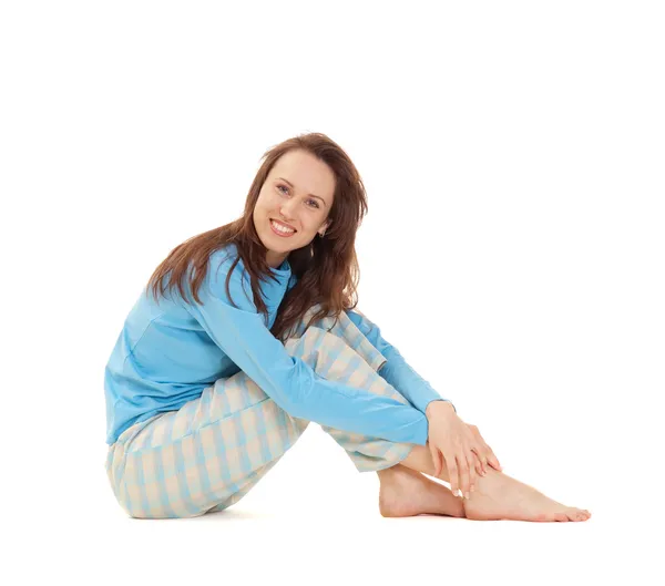 Mujer sonriente en pijama azul sentada en el suelo —  Fotos de Stock
