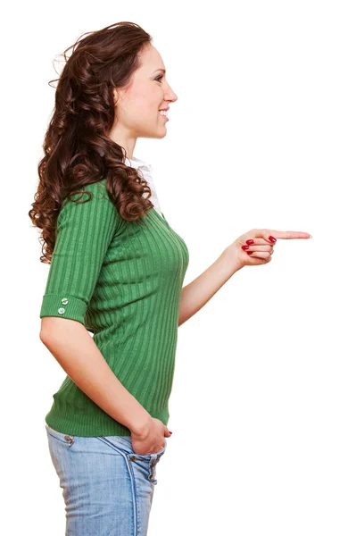 Smajlík mladá žena ukazuje na něco — Stock fotografie