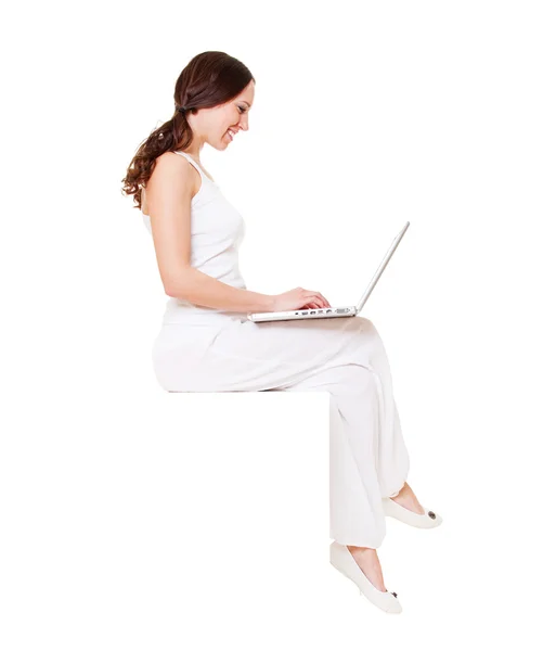 Gülen genç kadın laptop ile oturuyordu — Stok fotoğraf