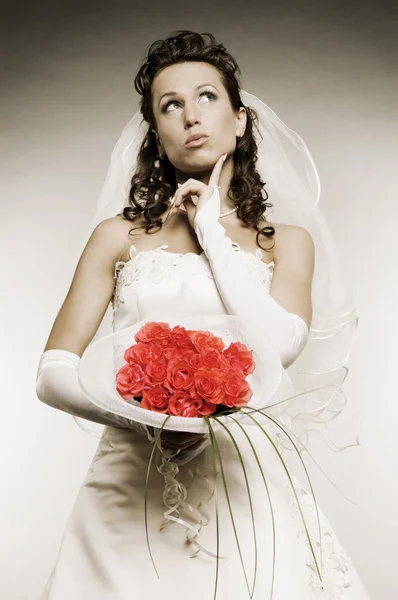 Mariée réfléchie avec un bouquet de fleurs — Photo
