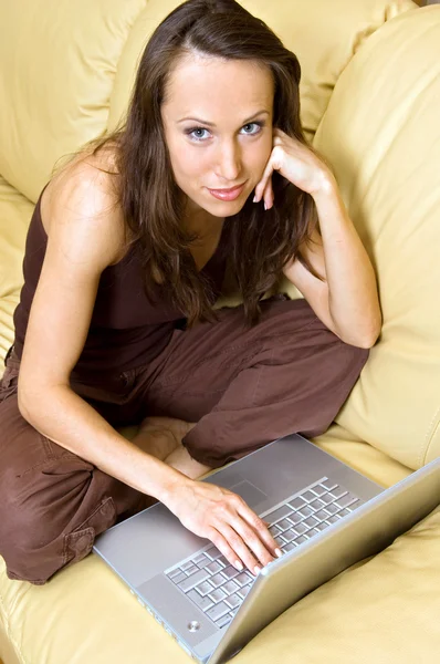 Γυναίκα στο σπίτι με laptop στον καναπέ — Φωτογραφία Αρχείου