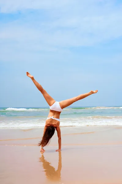Mulher fazendo cartwheel na praia — Fotografia de Stock
