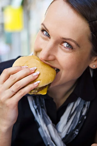 Mulher comendo hambúrguer saboroso — Fotografia de Stock