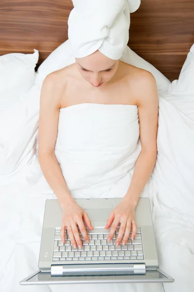Žena mít relaxem v posteli s notebookem — Stock fotografie