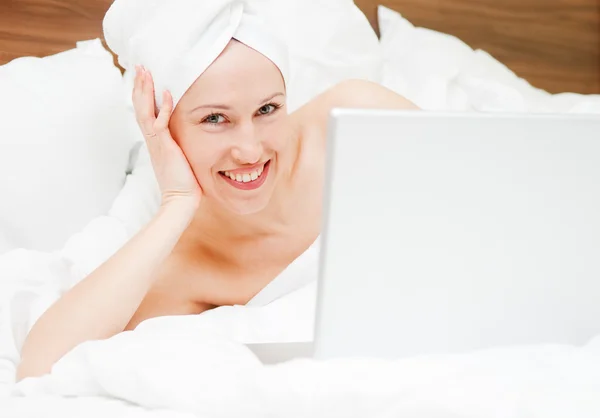 Mujer en su mal con el ordenador portátil después de la ducha —  Fotos de Stock