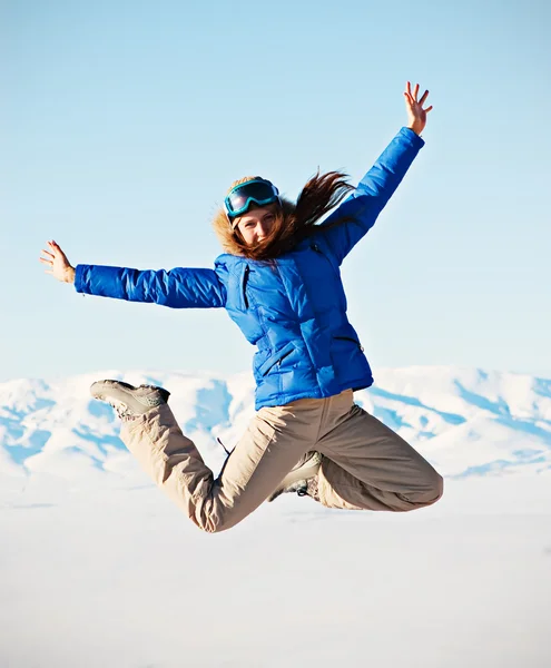 Woman jumping against snowy mountains — Stock Photo, Image