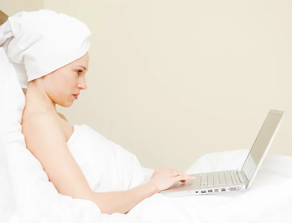 女人躺在床上用的笔记本电脑 — 图库照片