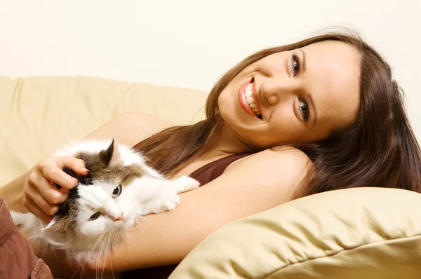 Wanita berbaring di sofa dengan kucingnya — Stok Foto
