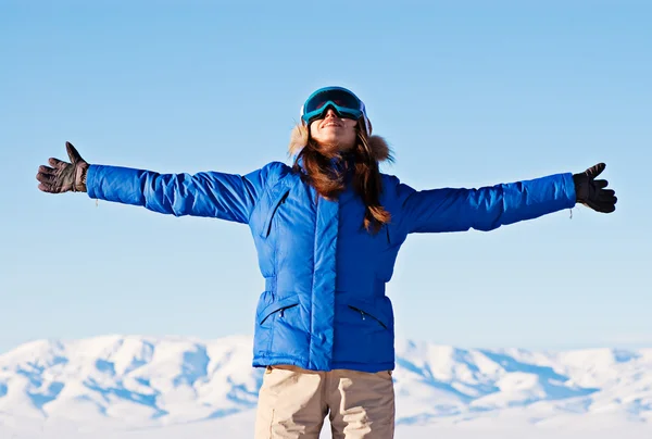 Woman standing against snowy mountains and blue sky — Stock Photo, Image