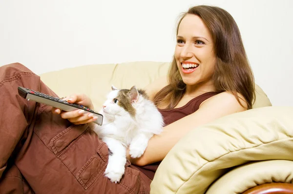 Kvinnan tittar på tv med hennes katt — Stockfoto