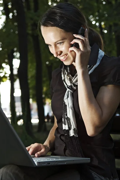 Woman with laptop and phone — Stock Photo, Image