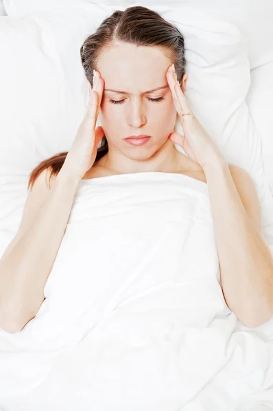 Frau mit Migräne liegt im Bett — Stockfoto