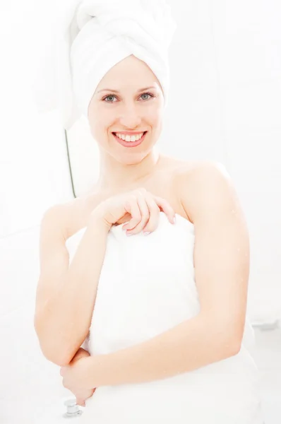 Молодая улыбающаяся женщина в белых полотенцах — стоковое фото