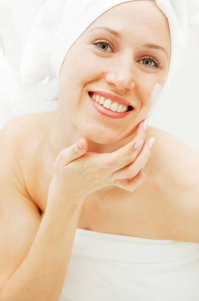 Mujer joven sonriente con cara crema después de la ducha — Stockfoto