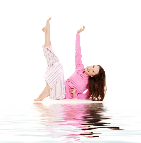 Молодая женщина в розовой пижаме расслабляется — стоковое фото