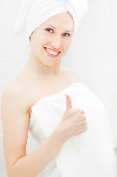 Jovem mulher em toalhas brancas mostrando polegares para cima — Fotografia de Stock