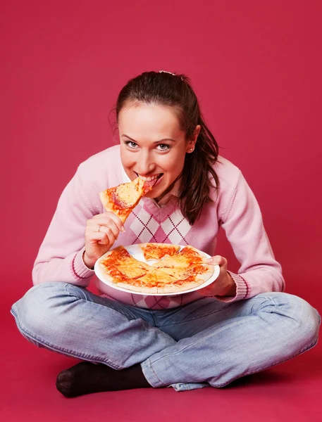 Giovane donna con pizza seduta sul pavimento — Foto Stock