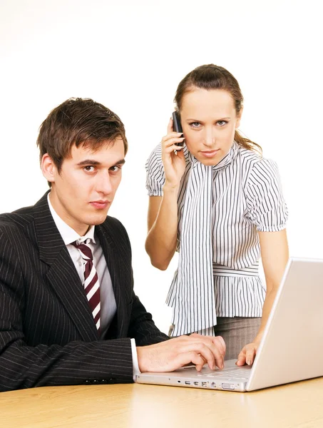 Молодой бизнесмен с ноутбуком и секретарем с телефоном — стоковое фото