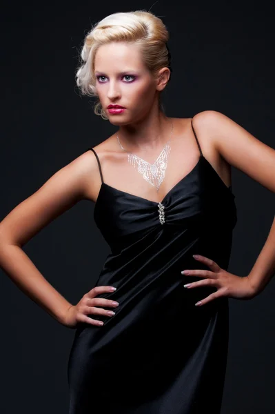 Glamour-Blondine vor dunklem Hintergrund — Stockfoto