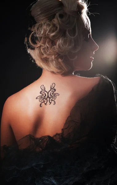 Sexy blonde met tatoeage op haar rug — Stockfoto