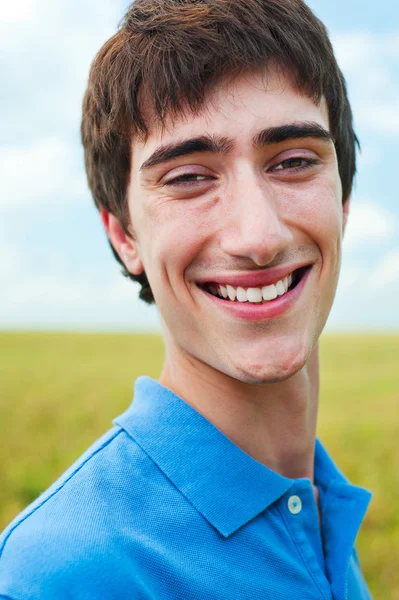 Šťastný mladý muž proti modré obloze — Stock fotografie