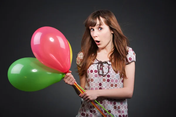 Удивлённая девушка с воздушными шарами — стоковое фото