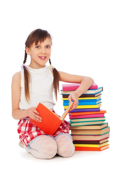 Smiley skolflicka sitter nära böcker — Stockfoto
