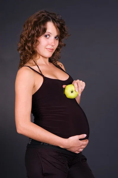 Беременная женщина с яблоком — стоковое фото