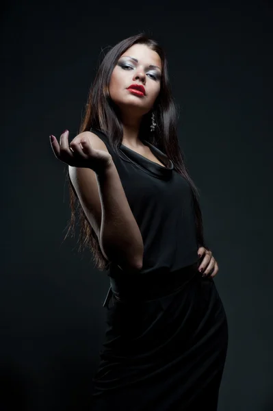 Грациозная молодая женщина в черном платье — стоковое фото