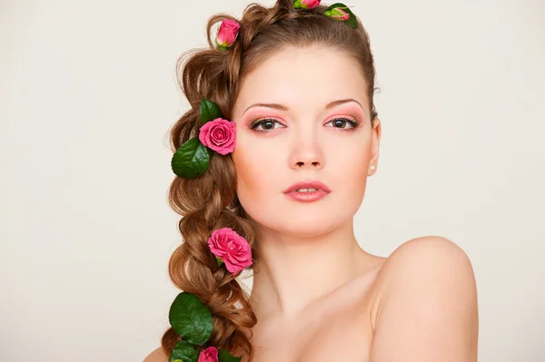 Mujer atractiva con rosas en el pelo —  Fotos de Stock