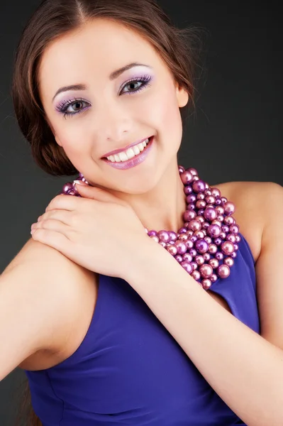 Kvinna i lila klänning med pärlor — Stockfoto