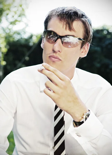 Uomo d'affari in occhiali da sole fumare la sigaretta — Foto Stock