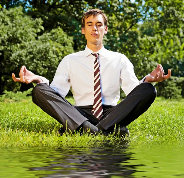 Businessman relaxing on the grassland — Stock Photo, Image