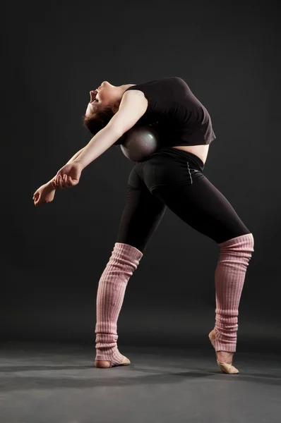 Flexible sportswoman with ball — Stock Photo, Image
