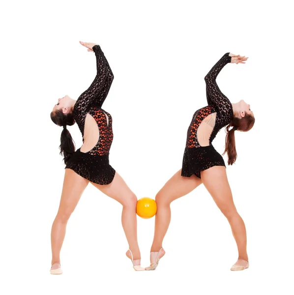 Two smiley gymnasts posing with yellow ball — Stock Photo, Image