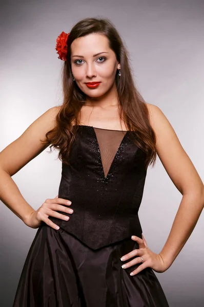 Damen i svart klänning med blommor i håret — Stockfoto