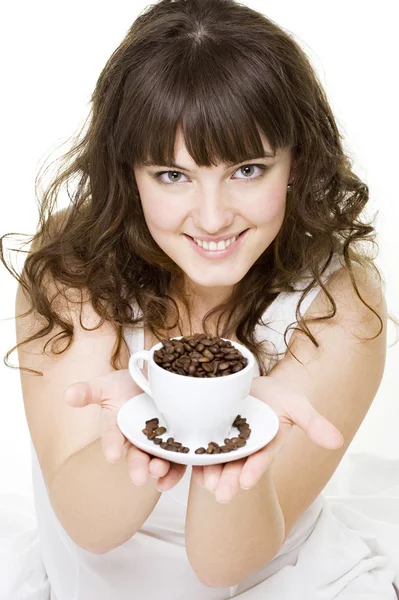 Улыбающаяся молодая женщина с чашкой кофейных зерен — стоковое фото