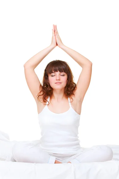 Жінка в ліжку займається вправами йоги — стокове фото