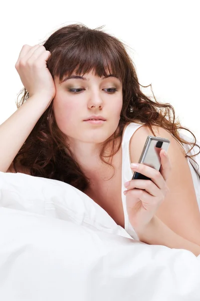 Femme couchée au lit et regardant le téléphone — Photo