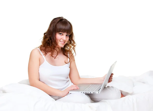 Frau sitzt mit Laptop im Bett — Stockfoto