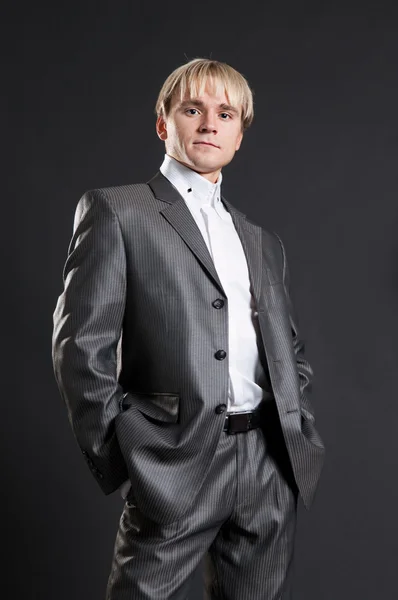 Ihärdig affärsman i grå kostym — Stockfoto