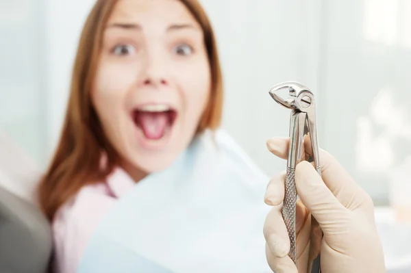 Испуганная женщина в кабинете дантиста — стоковое фото
