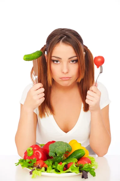 Kobieta siedzi w pobliżu talerz z warzywami — Zdjęcie stockowe