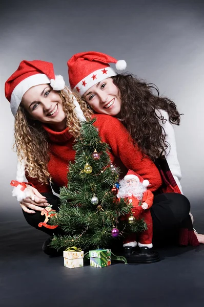 Lovely girls with santa and christmas tree — Stock Photo, Image