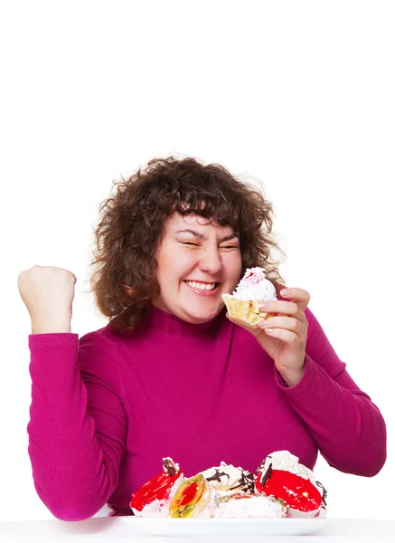 Fet kvinna äta bakelse med glädje — Stockfoto
