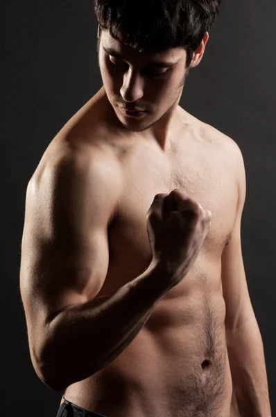 Sportovec při pohledu na jeho biceps — Stockfoto