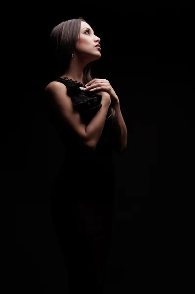 Junge schöne Frau betet in der Dunkelheit — Stockfoto