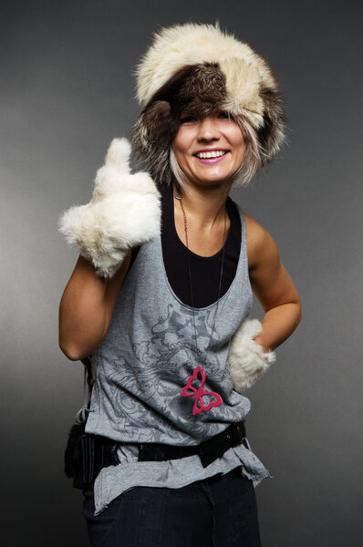 Веселая молодая женщина показывает большие пальцы вверх
