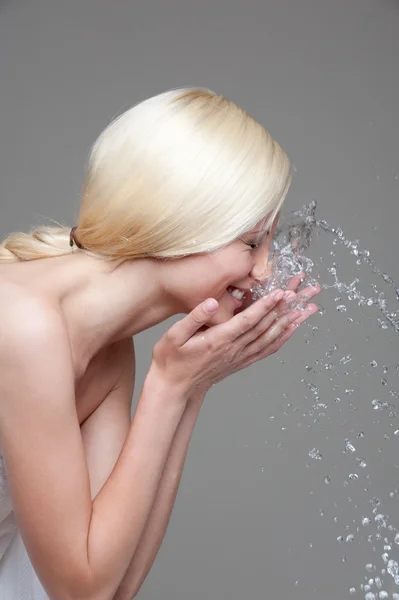 Joven rubia lavándose la cara — Foto de Stock