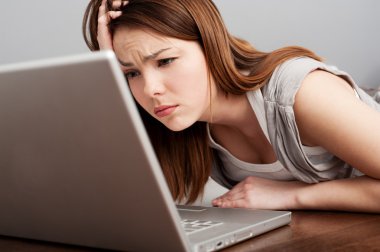 Fatigued student looking on laptop clipart